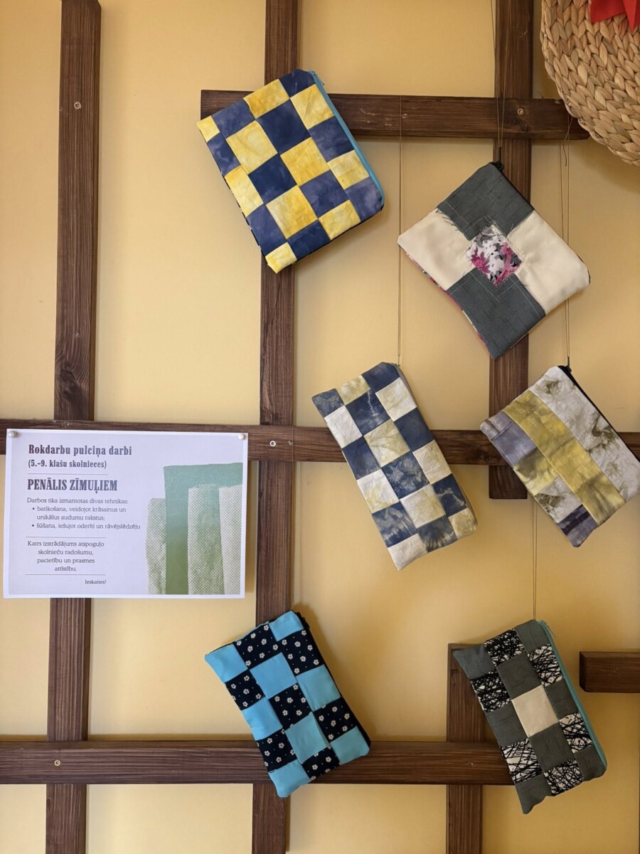 Uz dzeltenas sienas ar koka rāmjiem izvietoti seši ar rokām darināti, stepēti penāļi. Blakus tiem atrodas balta zīme ar tekstu 